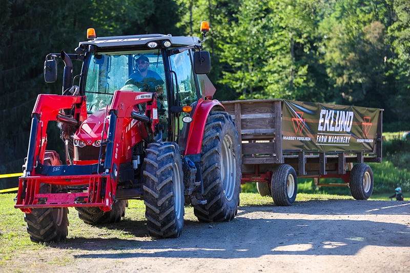 Massey Ferguson tractor hauling an Eklund-branded wagon during a live demo at Eklund Farm Machinery
