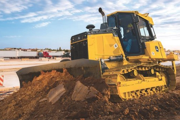 John Deere 700K crawler dozer pushing soil on a construction site, ideal for heavy-duty grading and earthmoving tasks.