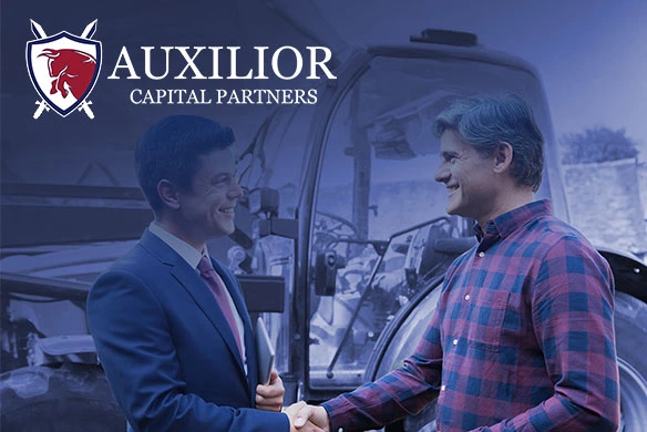 Businessman and farmer shaking hands in front of a tractor, representing financing support from Auxilior Capital Partners.