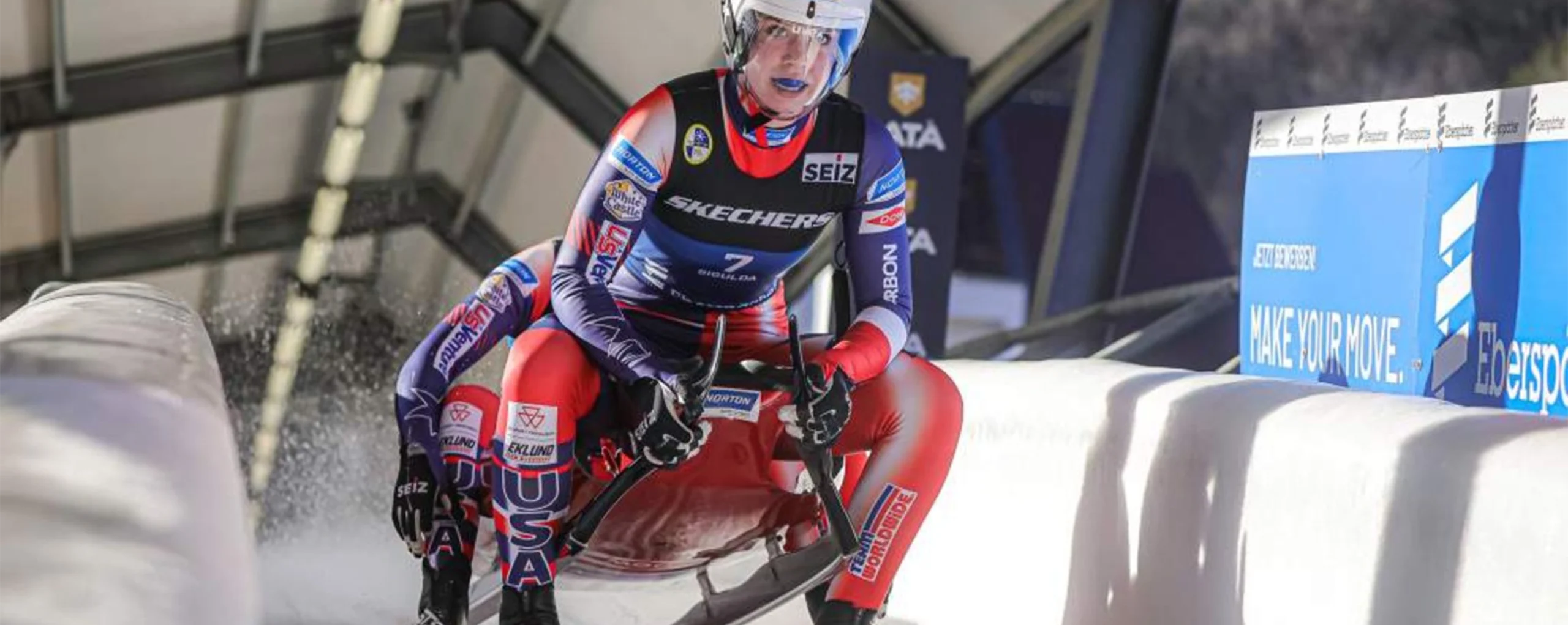 Team USA luge athletes racing on an ice track during the Winter Games.